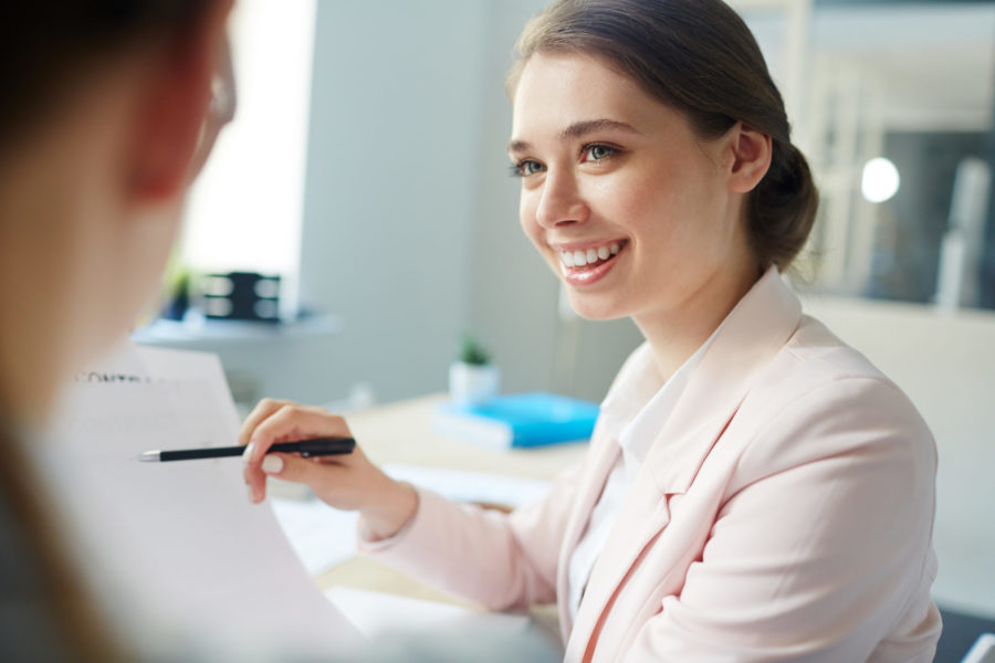 Smiling accountant pointing at financial document to discuss tax strategies with client