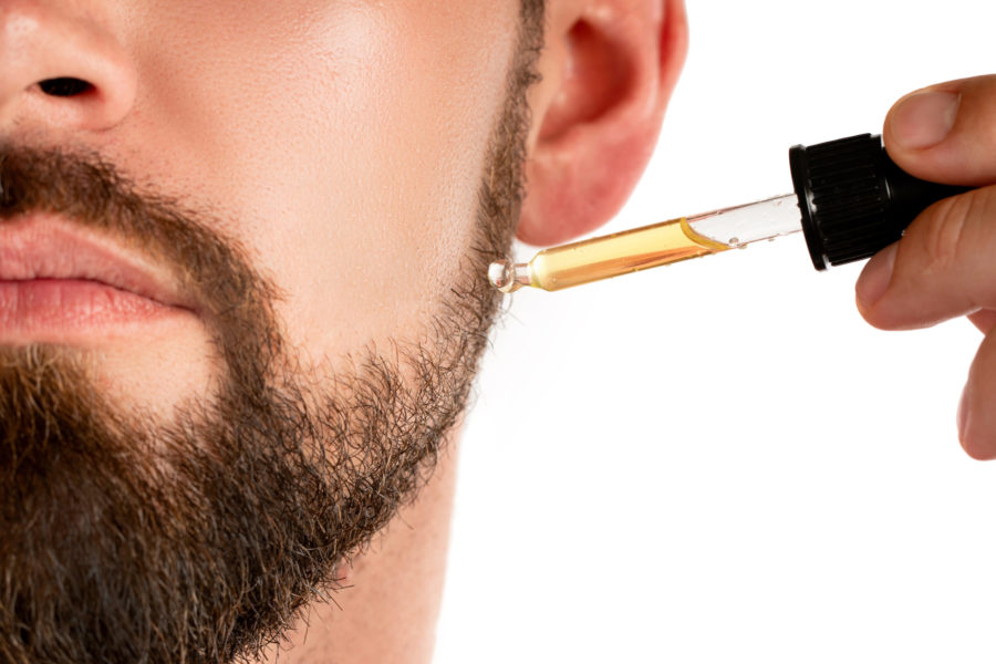 Closeup of male face and pipette with a oil for a beard growth illustrates recurring revenue business model