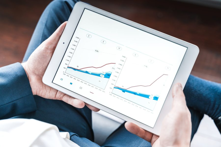 Businessman working on a tablet reviewing growth versus value charts