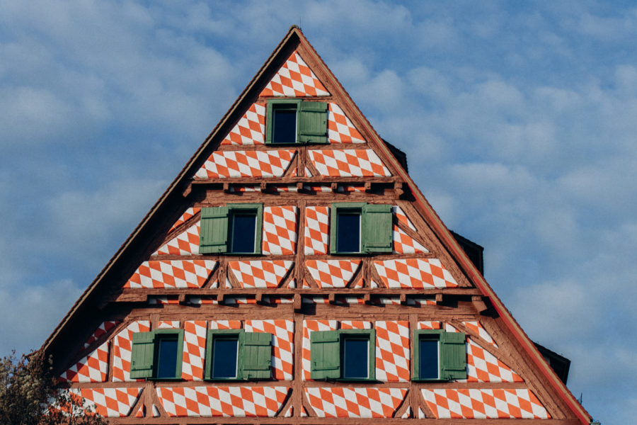 Beautiful old wooden Switzerland Structure beam house with white and orange plaster.